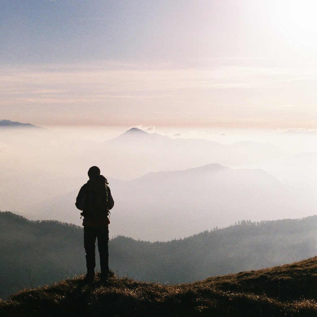 man hiker looking at mountains skyline nature
