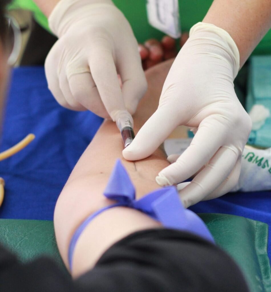 A healthcare professional administering an injection to a patient's arm during a medical procedure.