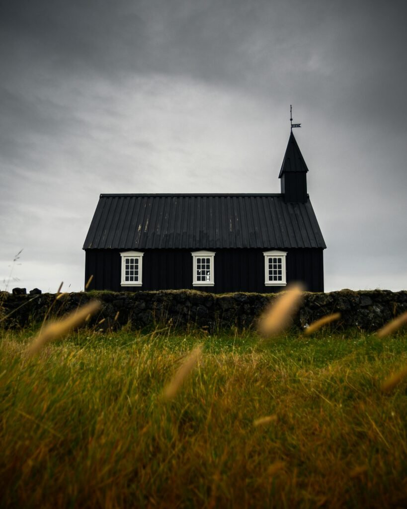Moody landscape of the historic Black Church amidst grassy Icelandic countryside.