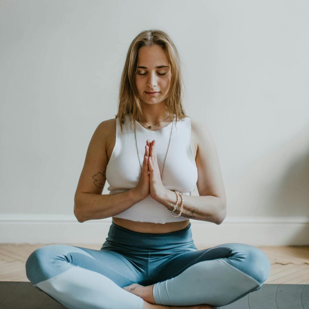 A serene image of a woman practicing meditation indoors, promoting mindfulness and wellbeing.