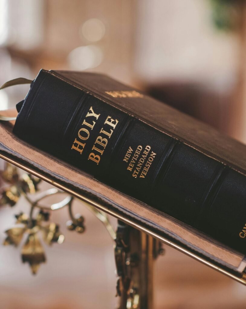 Holy Bible open on a stand inside a church, symbolizing faith and spirituality.