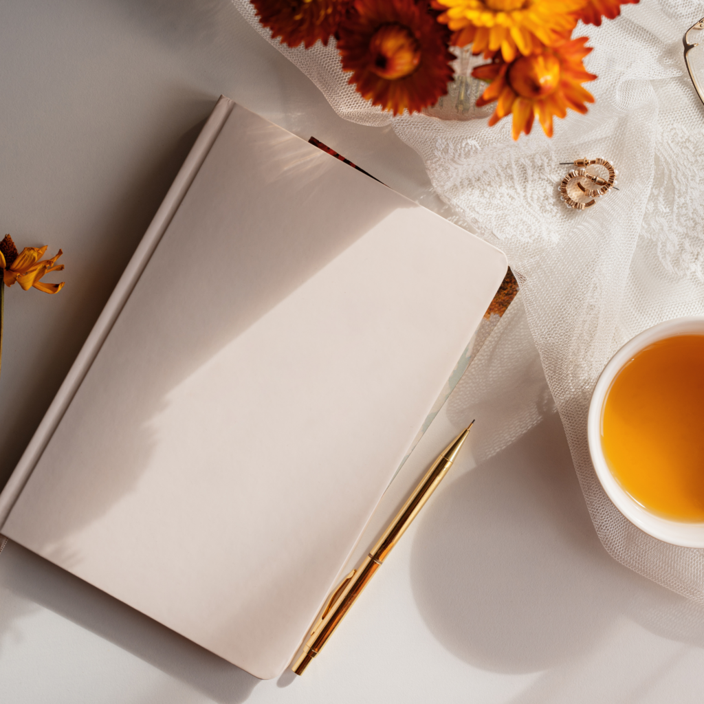 notebook on desk orange flowers tea planner gold pen